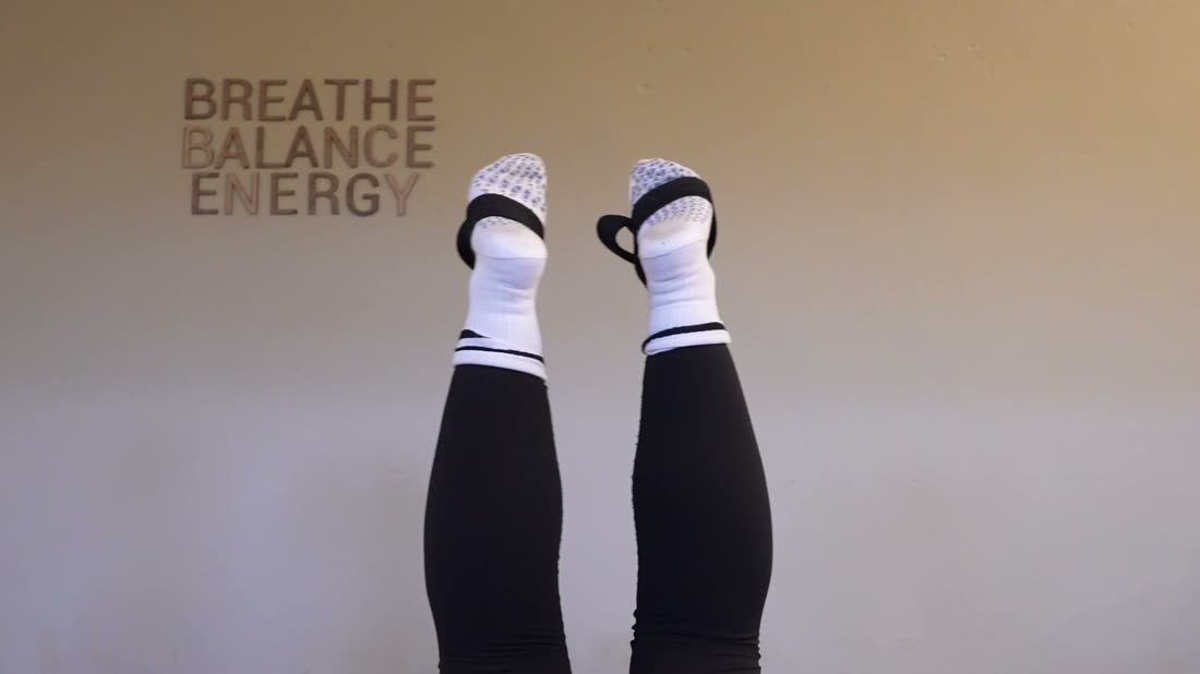 Grip-sokker i reformer-salen med teksten Breathe Balance Energy